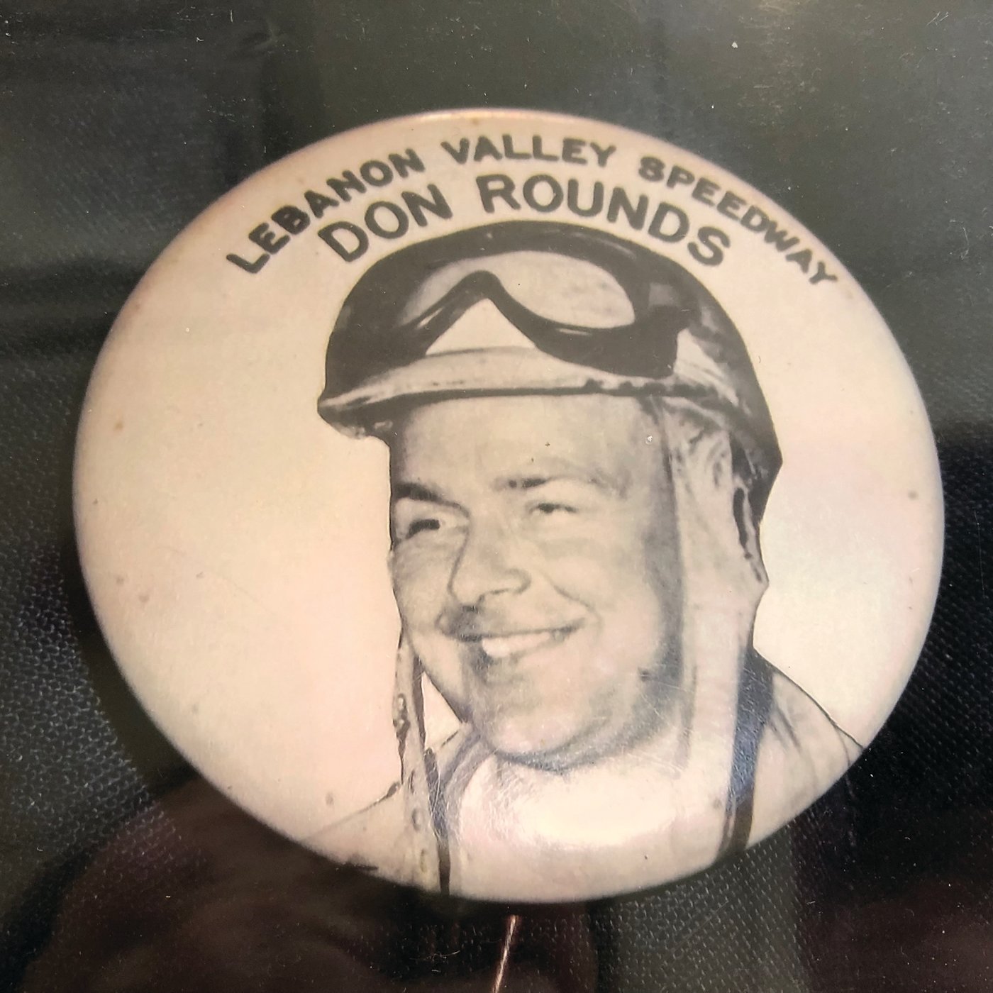Souvenirs such as small plastic cars and this collectible Don Rounds button were available for purchase at the races.